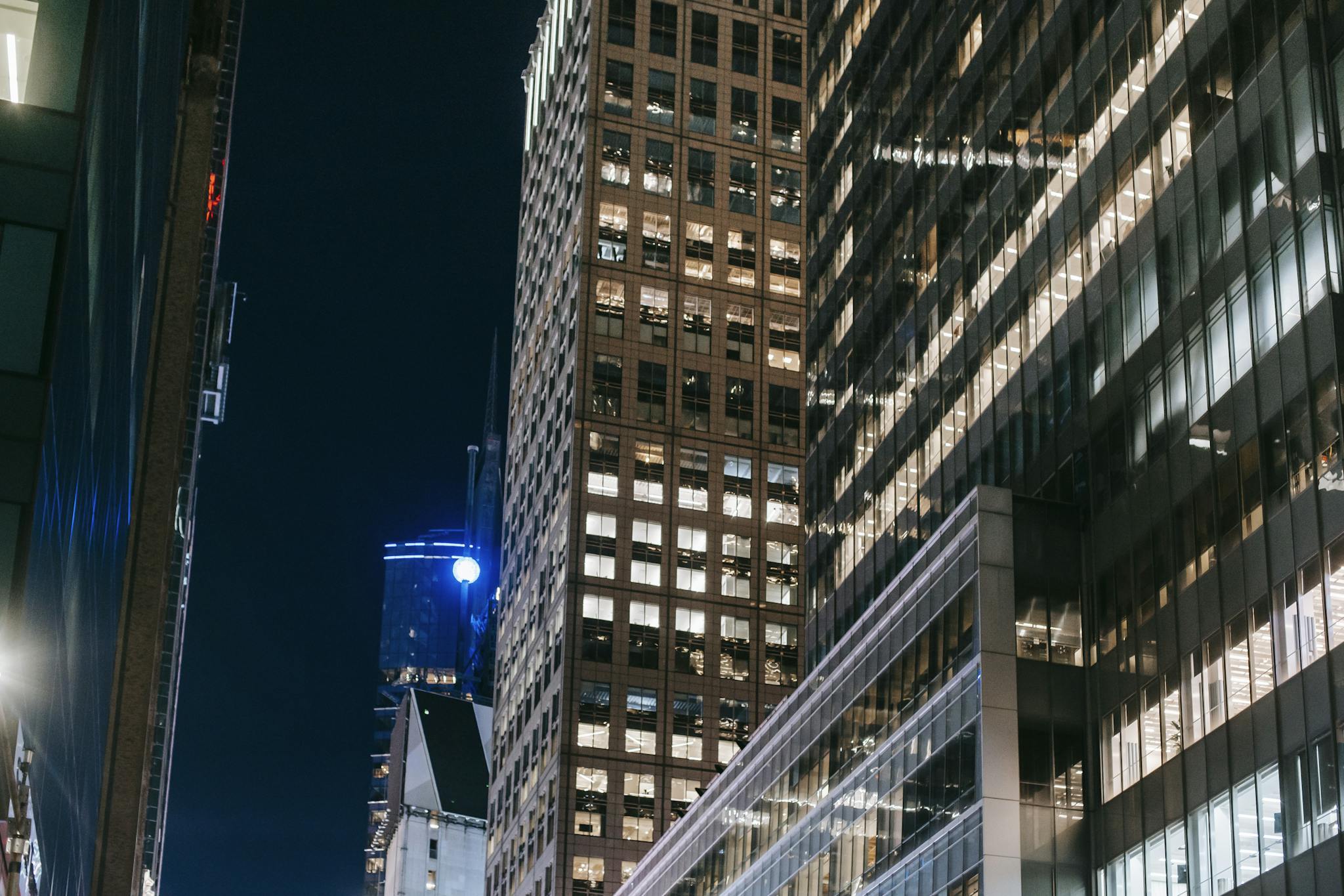 Modern skyscrapers with bright lights create a dramatic night scene in the city.